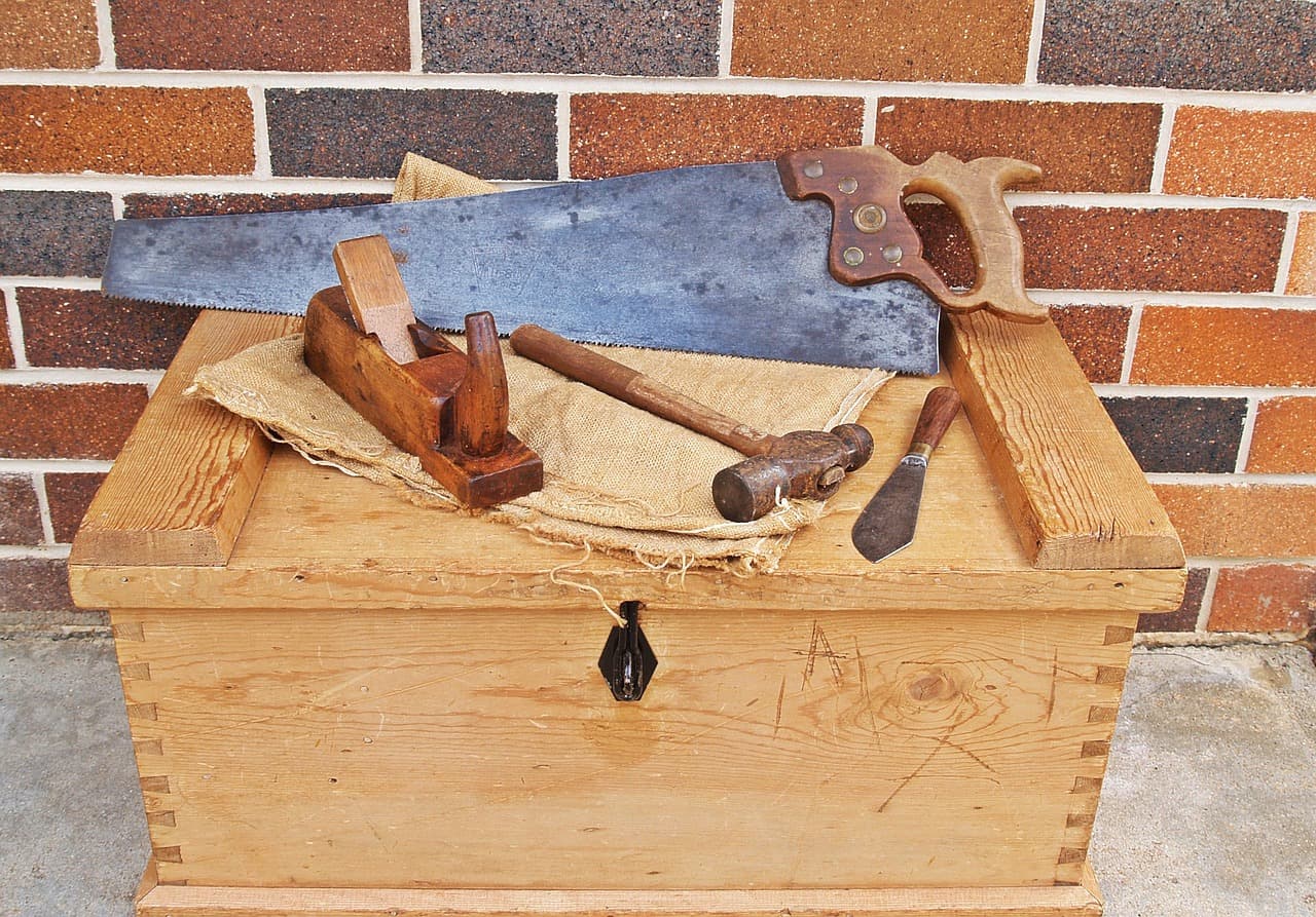A carpenter's wooden toolbox full of hand tools